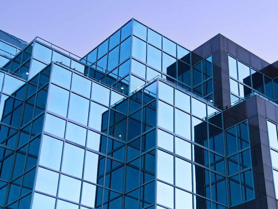 A glass curtain wall seen straight on, the panels repeating to the edge of the frame.